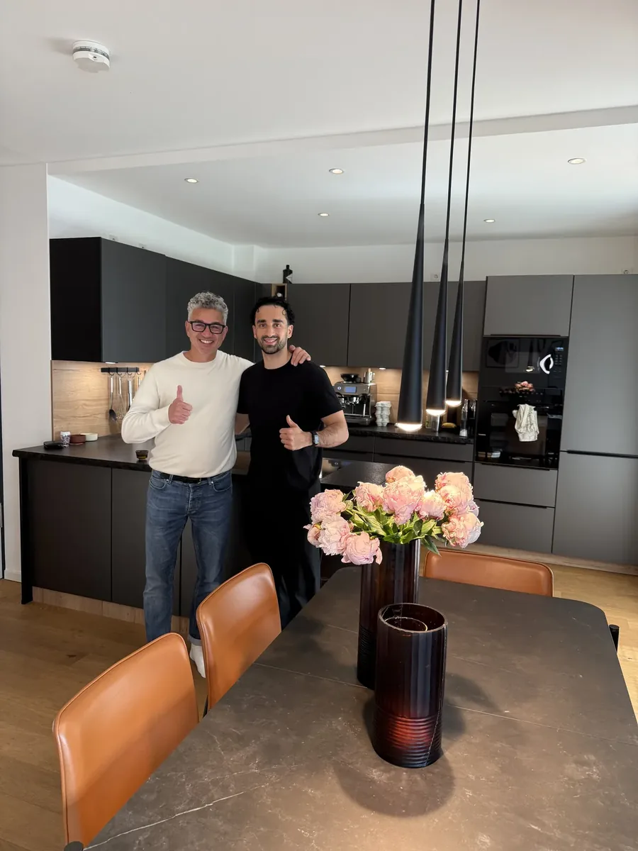 Zufriedener Stylekonzept-Kunde mit Inhaber Raed Hamouri in moderner schwarzer Designkueche