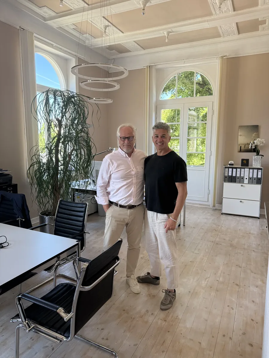 Zufriedener Stylekonzept-Kunde mit Inhaber Raed Hamouri in stilvoll renoviertem Buero