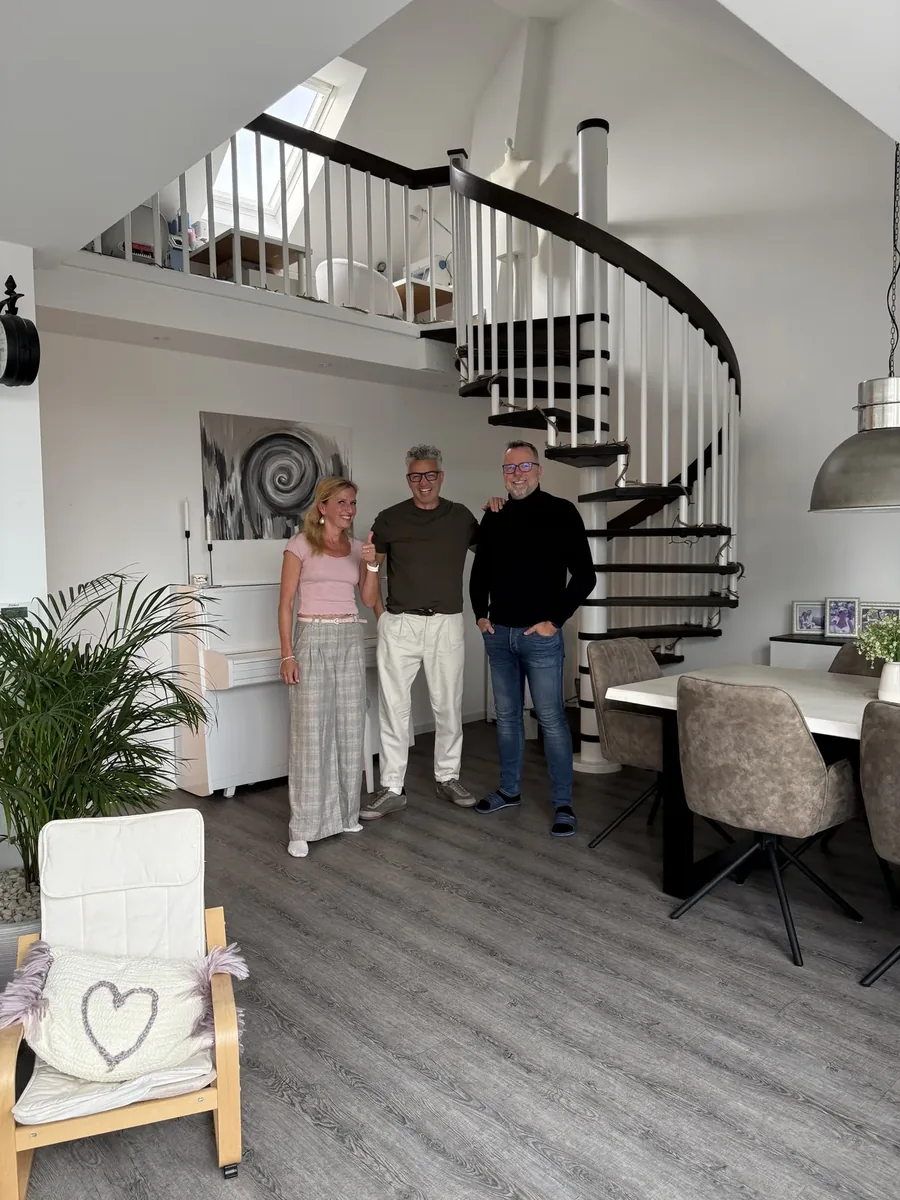 Zufriedene Stylekonzept-Kundenfamilie im hellen renovierten Wohnraum